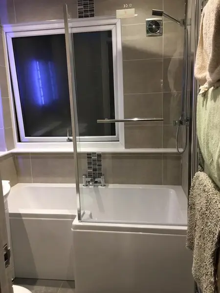 Bath with grey tiling and vertical mosaic feature