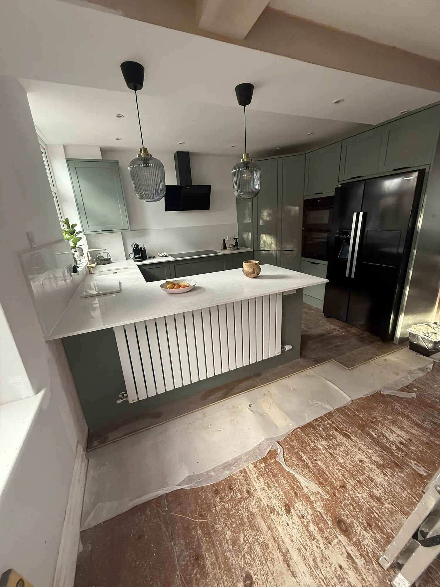 Sage shaker kitchen with island and statement pendant lighting